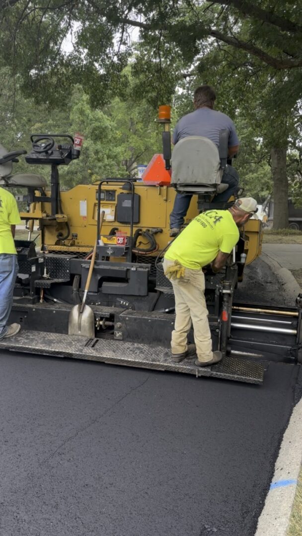 Workers paving a road with asphalt.