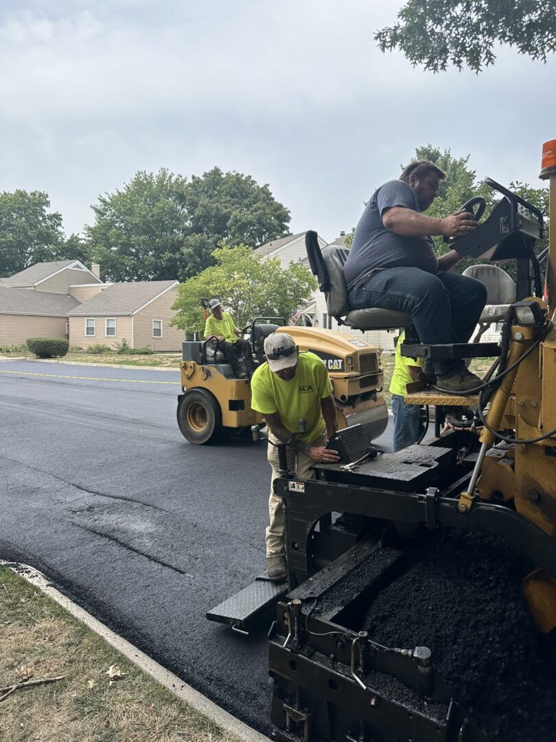 Workers paving road with asphalt.