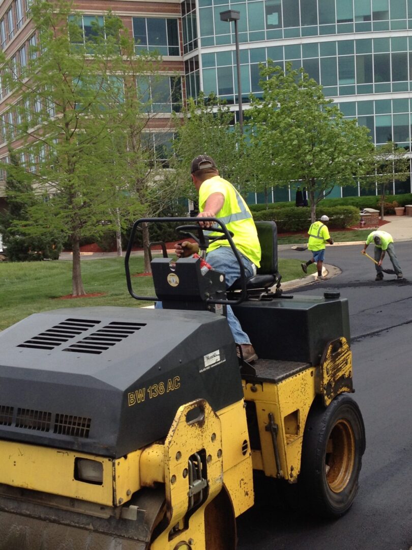 Yellow roller compactor paving asphalt.