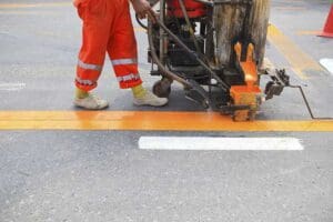 Machine and worker at road construction